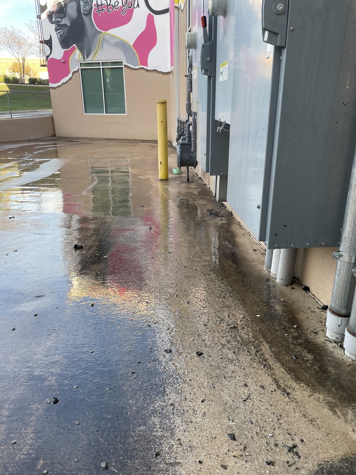 Before: dirty commercial exterior with stained walls and concrete